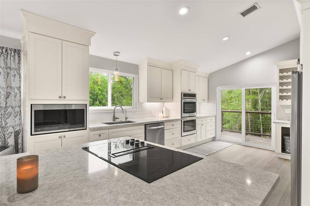 The kitchen boasts modern stainless steel appliances and features an oversized island, perfect for gathering and entertaining guests.