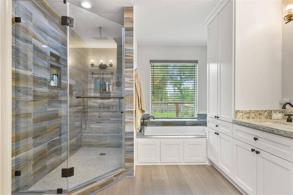 The primary suite bathroom also boasts a luxurious and spacious layout that includes a large walk-in shower and a separate bathtub.