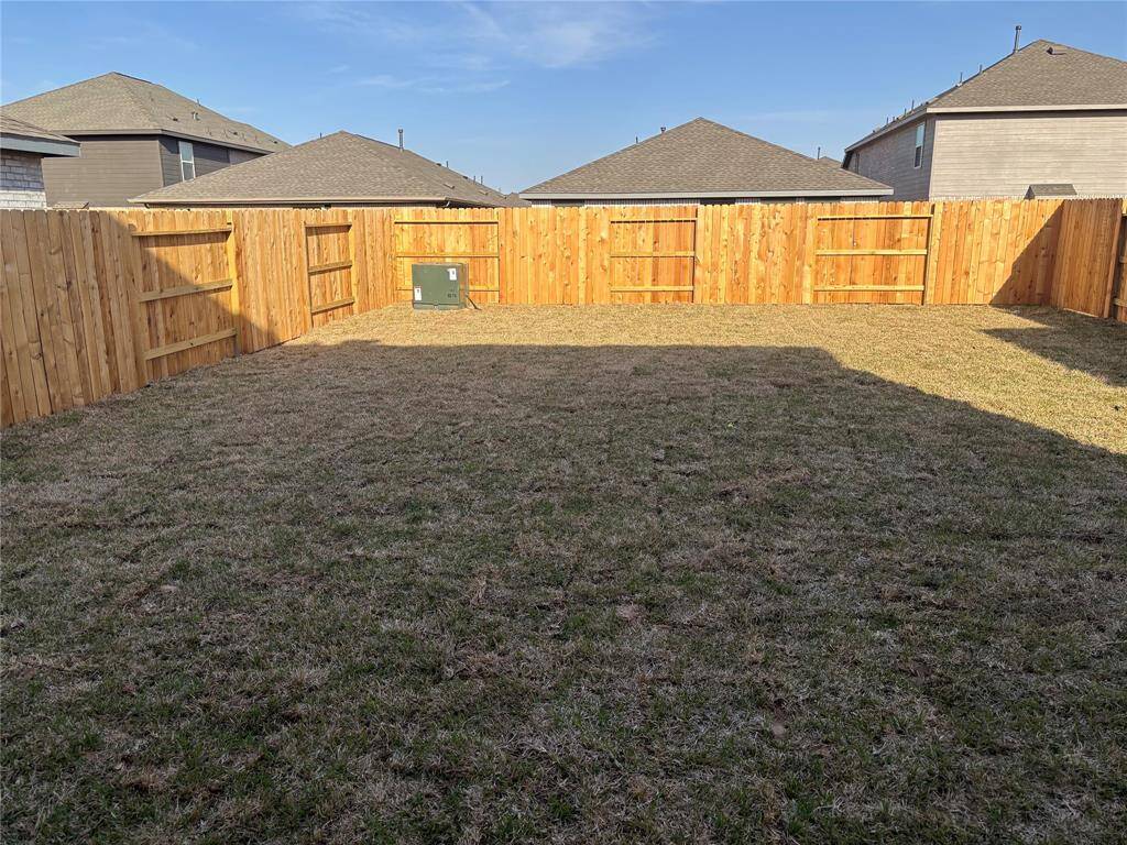 A spacious, fenced backyard with a well-maintained lawn, perfect for outdoor activities and privacy.