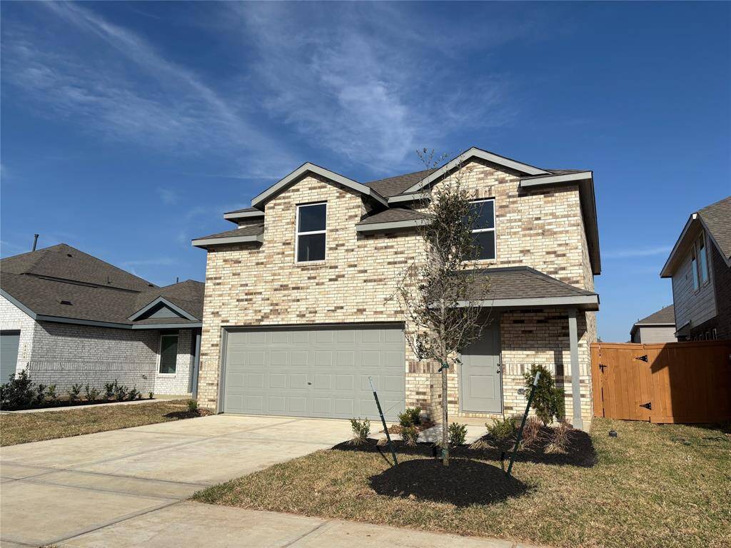 This is a two-story brick house with a double garage, neatly landscaped front yard, and a fenced backyard. The exterior features a neutral color palette and modern design, ideal for a family home.