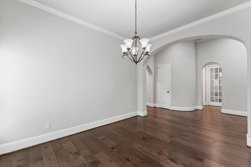 Arched doorways lead to adjacent rooms creating an open and inviting floor plan.