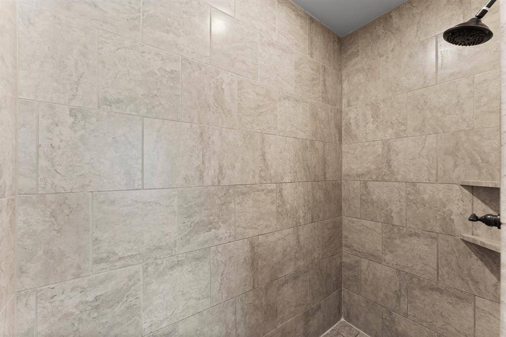 Massive walk-in shower with modern tile design.