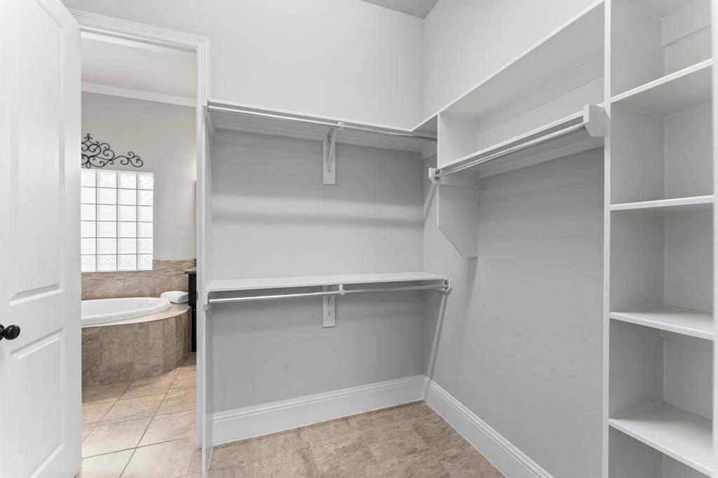 Spacious walk-in closet with built-in shelves and rods for ample storage.