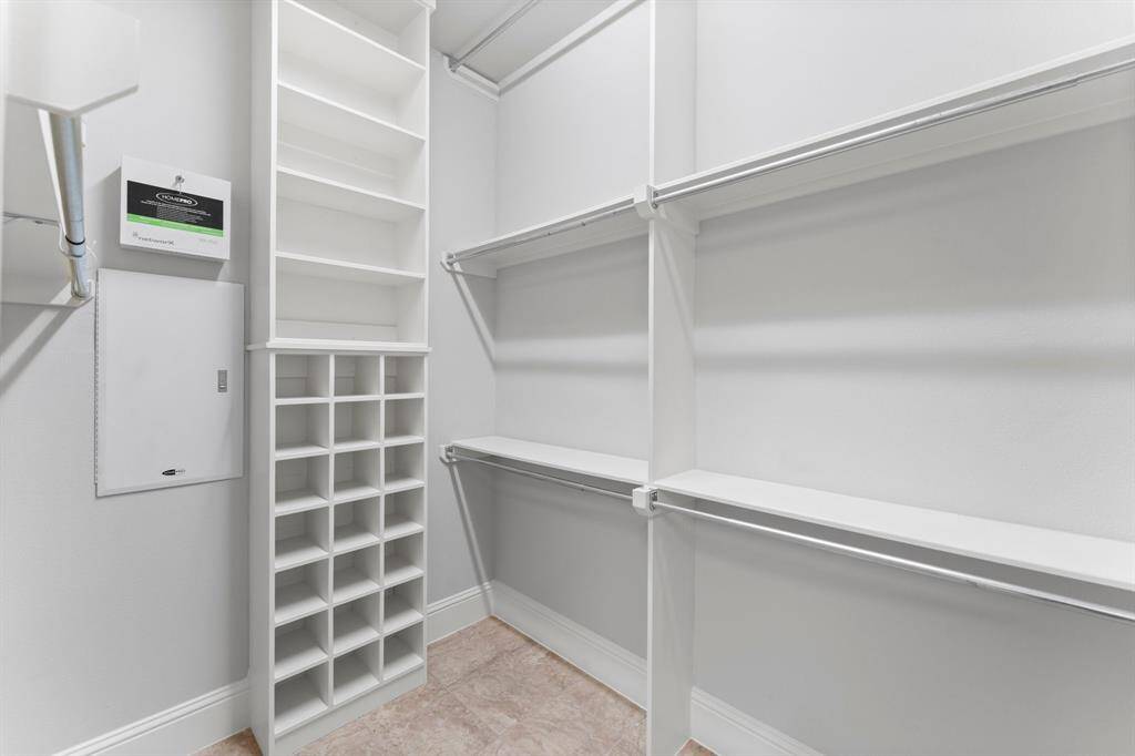 Well-organized walk-in closet with ample shelving, hanging space, and a shoe rack.