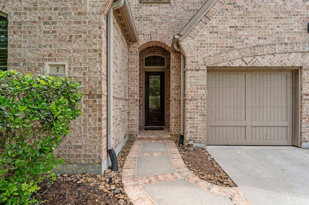 A charming path leads to an elegant arched front door, creating a welcoming entrance.