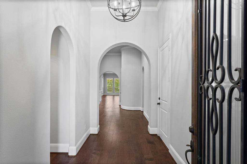 Inviting entryway, features elegant updated light fixture and rich hardwood floors.
