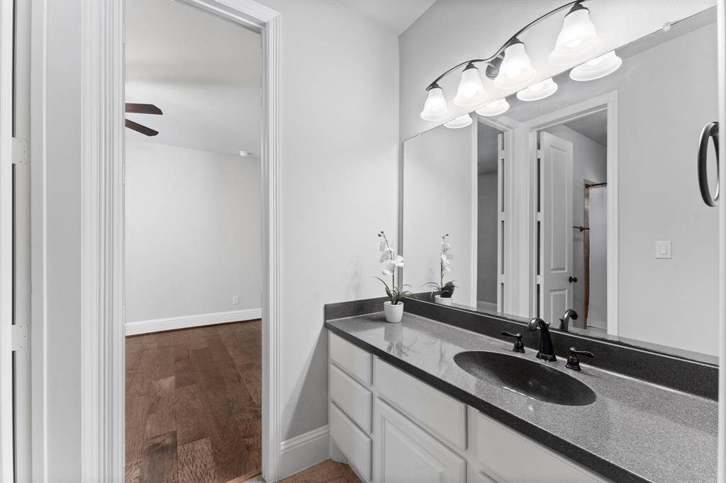 Modern bathroom featuring a sleek black granite countertop, and elegant vanity lighting.