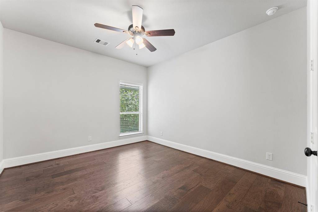 Spacious second bedroom with elegant hardwood floors and ample natural light.