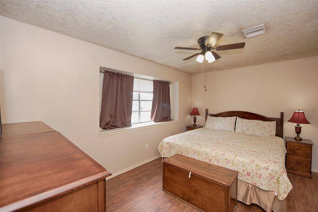 Spacious primary bedroom at the front of the home allows a private separation. Gorgeous updated wood laminated floors.