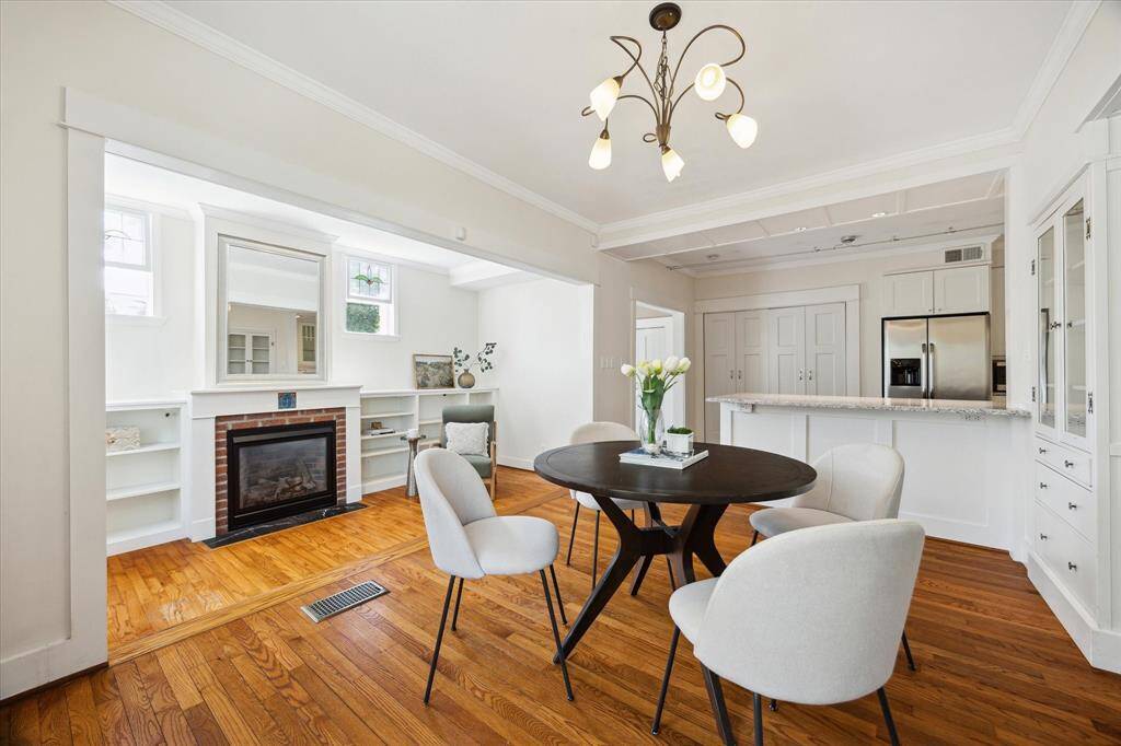 A stylish and airy dining space with built-in shelving, a sleek fireplace, and sight lines to the kitchen. A clean, functional layout perfect for both entertaining and everyday living.