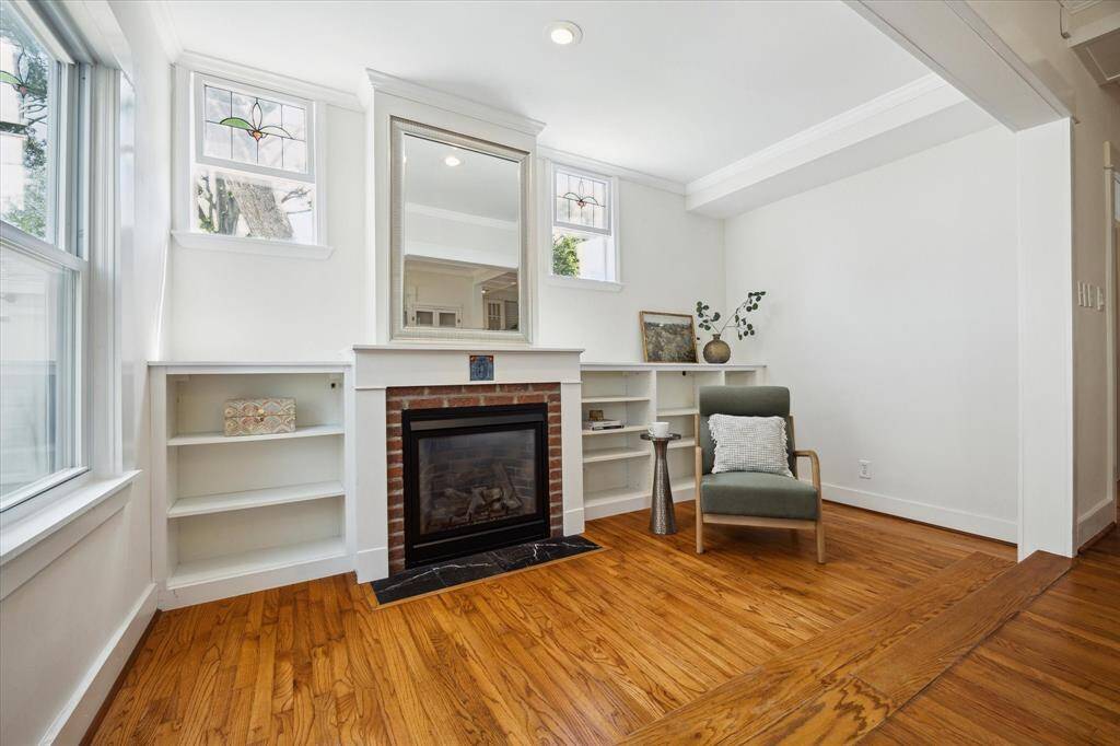 A cheerful corner surrounded by windows and built-in shelving. Ideal for reading, working, or a moment of calm.