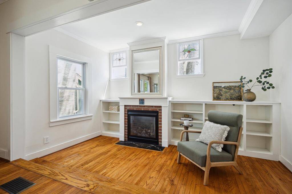 A bright and peaceful nook by the fireplace. Features original built-ins and transom windows that bring in tree-filtered light.