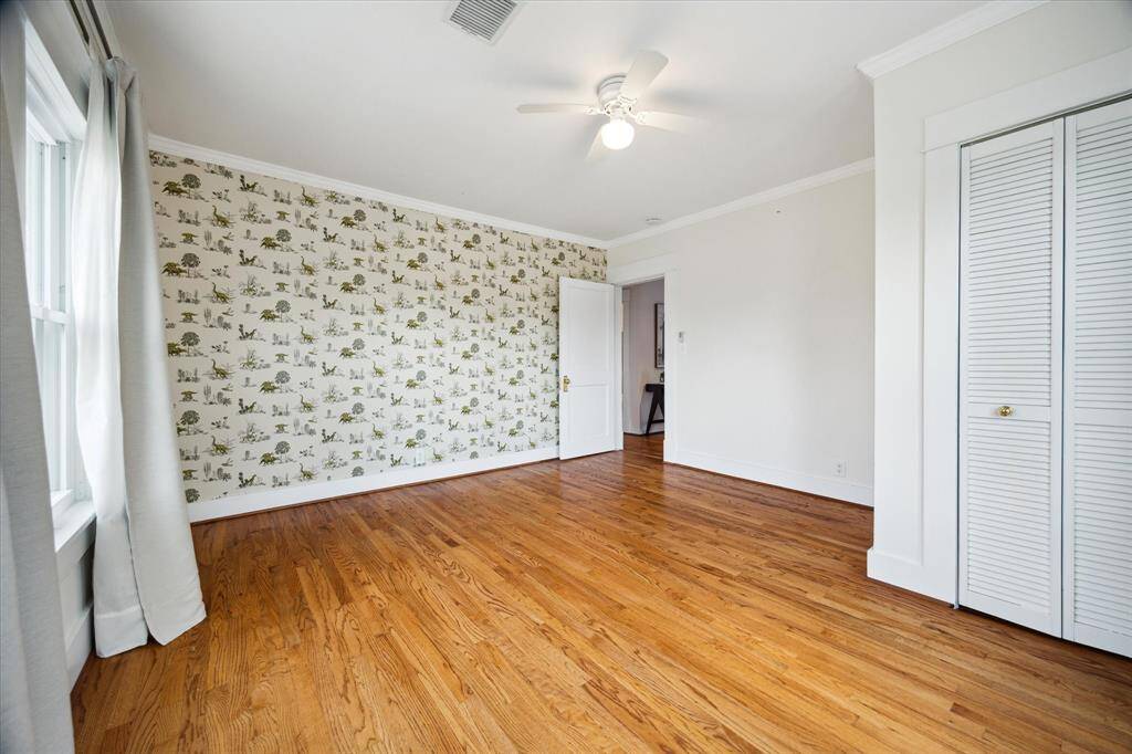A wide view of the bedroom’s generous floor space and double closets. Positioned to enjoy privacy and morning light.