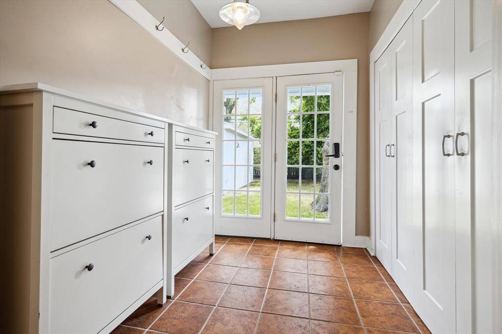 Mudroom, custom storage drawers, and glass doors opening to the backyard. A smart transition space for everyday coming and going.