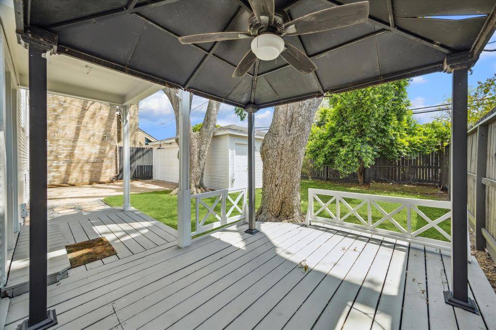 Covered deck area with ceiling fan, ready for year-round use. Offers space for outdoor dining, gathering, or quiet evenings under the trees.