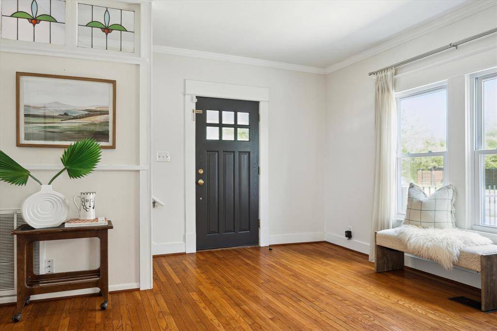 Inside the front door, natural light floods the living area with hardwood floors, crown molding, and a bright window seat,classic character meets modern warmth.
