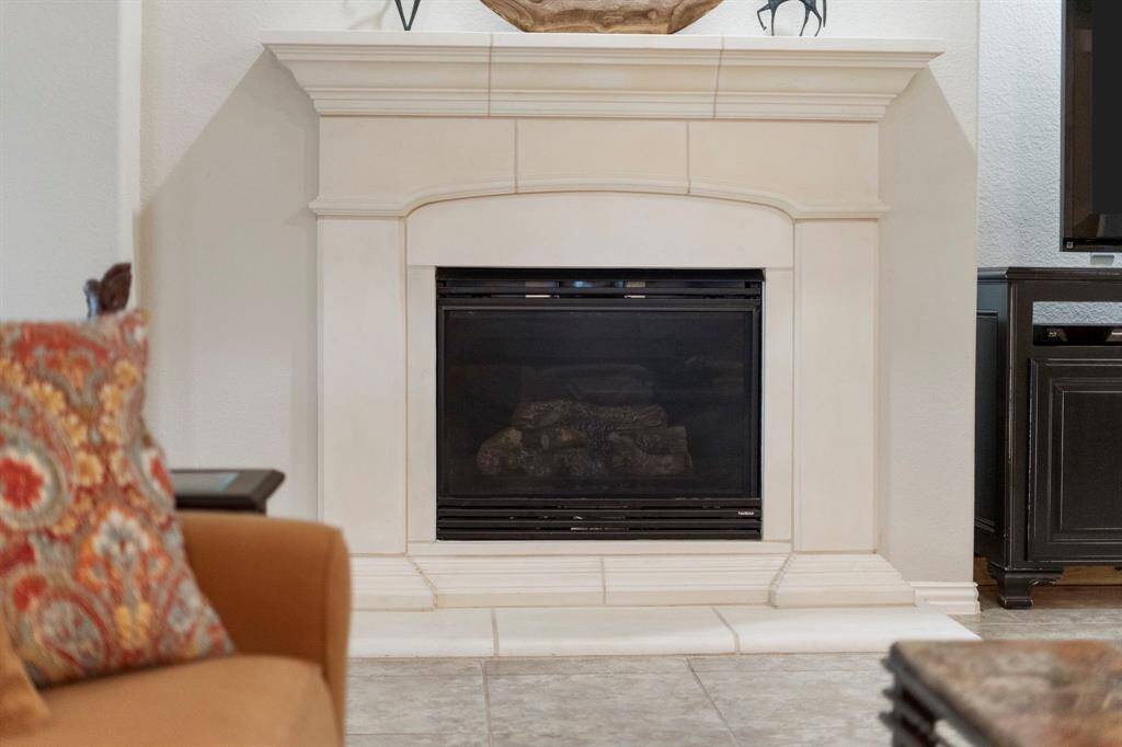 The classic cast-stone fireplace adds timeless style and warmth to the space.