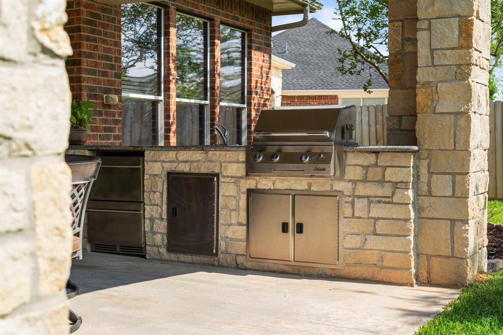 Step outside to a large covered patio with an OUTDOOR KITCHEN —ideal for entertaining year-round.
