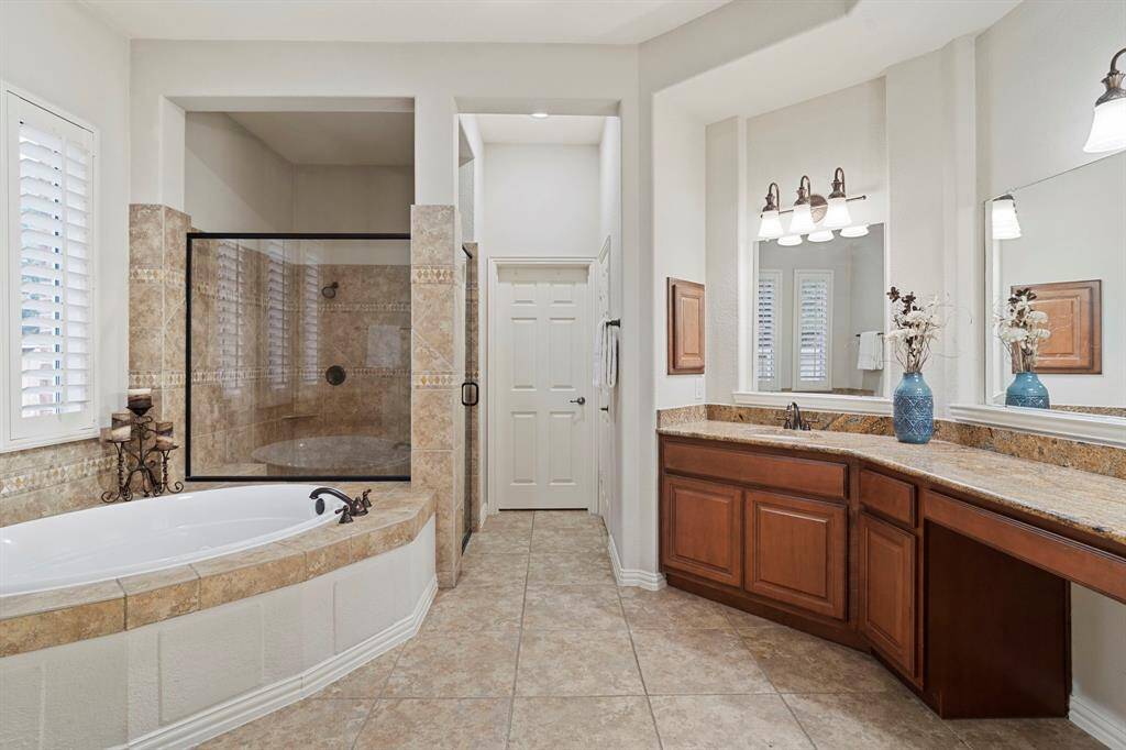 Spa-like ensuite bathroom complete with dual vanities, make up area, jetted tub, walk-in shower, linen closet, and a generous walk-in closet.