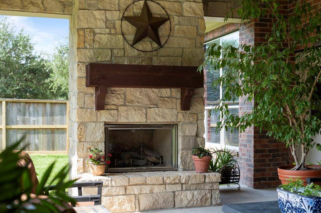 A majestic natural stone fireplace creates the perfect ambiance for outdoor entertaining.