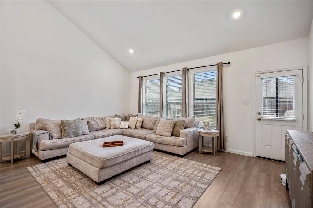This living room can easily fit Texas-sized sectionals and other large pieces of furniture. Three large windows overlook your peaceful backyard space.