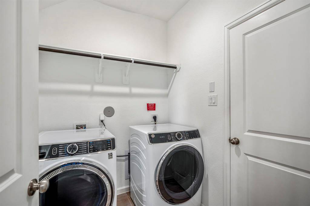 Utility room allows for hanging clothes. Door to the right leads to the garage.