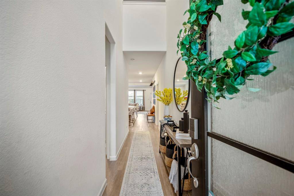 A long hallway with two-story ceilings greets you with vinyl flooring throughout this first floor.