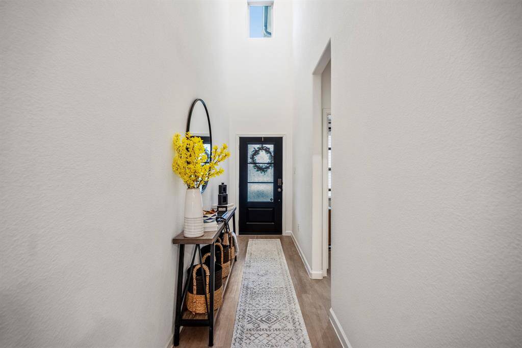 Reverse look at a this light-filled entryway. Hallway to the right leads to a bedroom and a full bath.