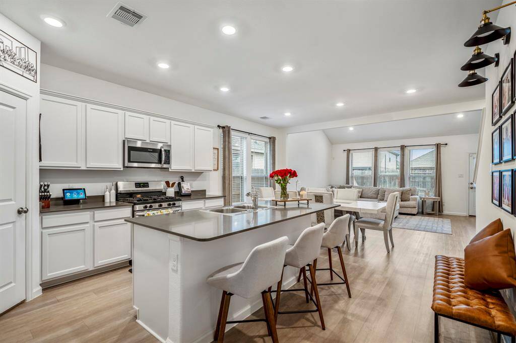 Down a long hallway into the heart of the home is this immaculate island kitchen that seats four people comfortably.