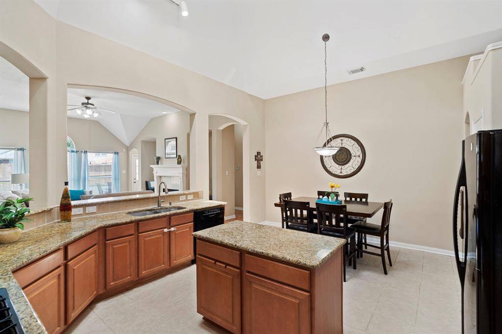 The light-filled kitchen is a true standout, complete with a center island, breakfast bar, granite countertops, pantry, and updated daylight lighting.