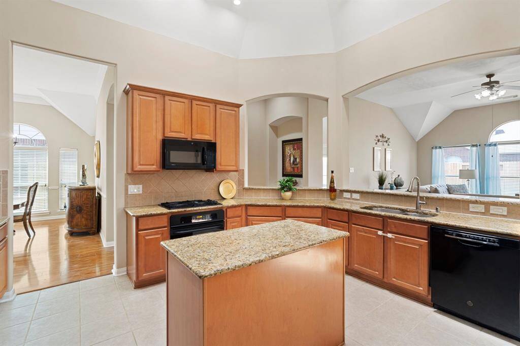 A center island anchors the kitchen, offering additional prep space, storage, and a perfect spot for gathering.