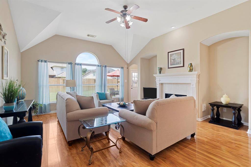 Step inside to an open-concept layout featuring high ceilings, rich wood flooring, and a handsome gas-log fireplace.