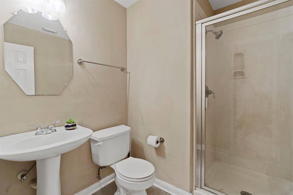 The full bathroom next to the home office features a walk-in shower.