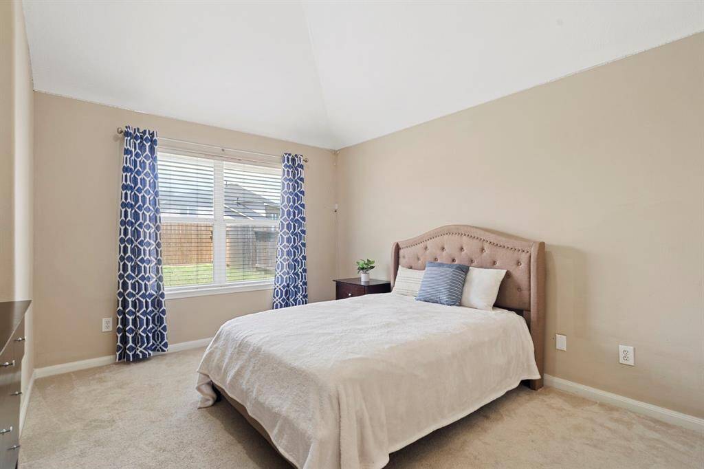 This charming secondary bedroom, located at the back of the home, offers peaceful and relaxing views.