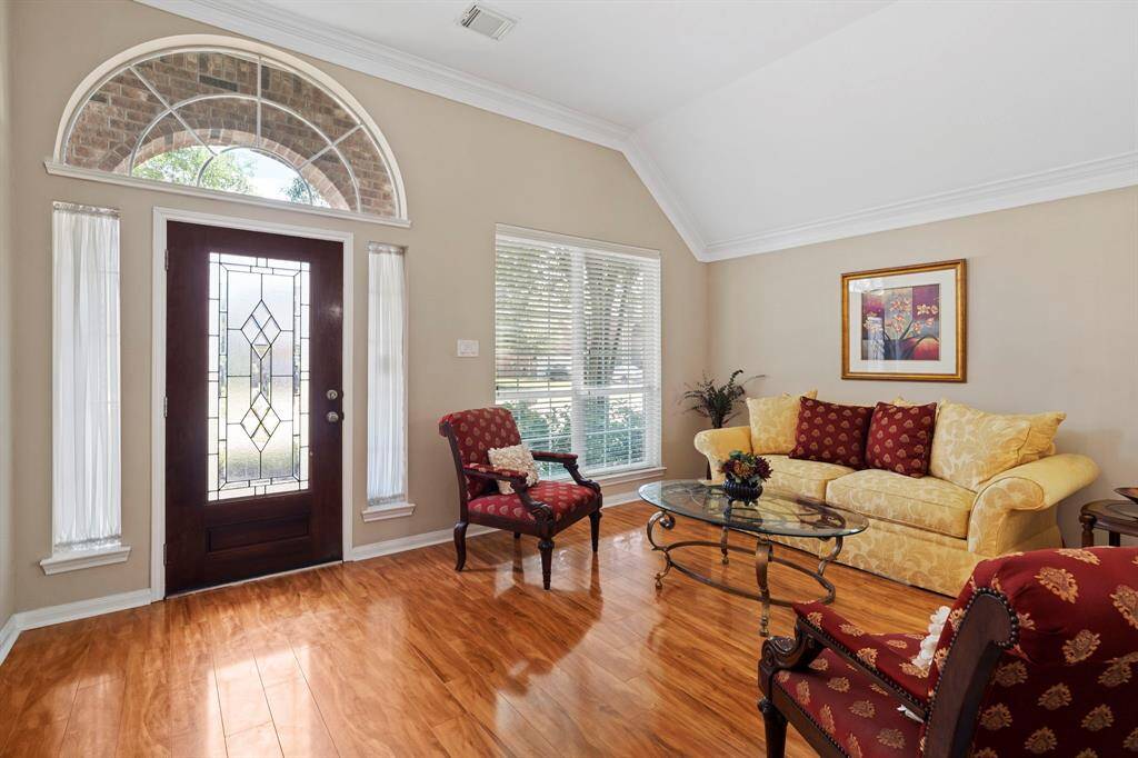 Solid wood and leaded glass front door with arched transom and sidelights fills the entrance to this home with natural light.