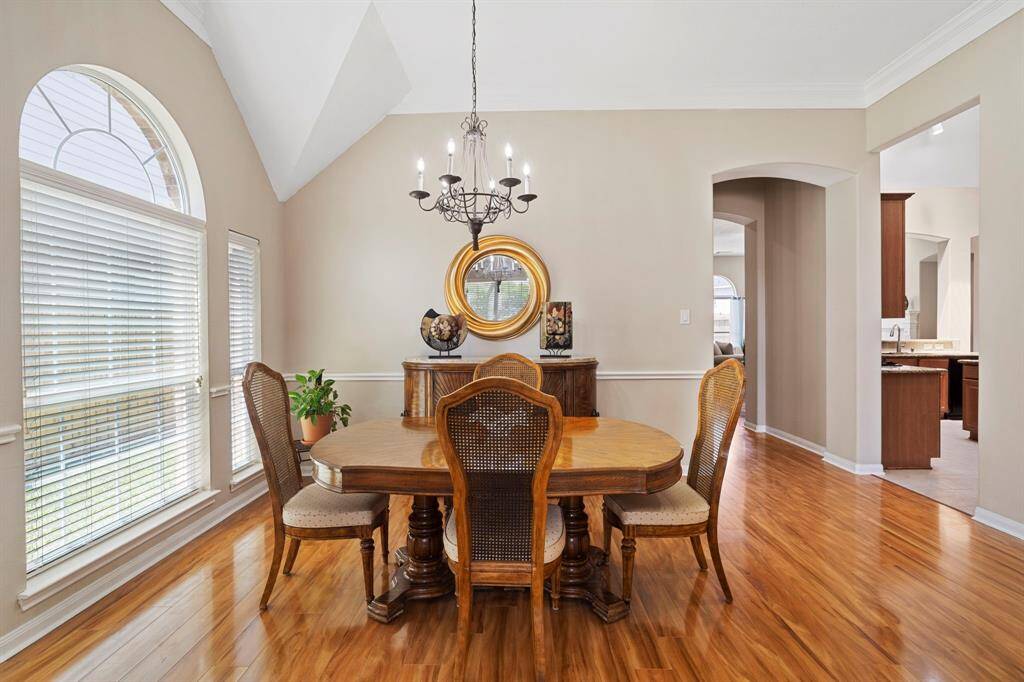 The formal dining room features a high ceiling and a large arched window that fills the space with natural light, creating an elegant and airy ambiance—perfect for entertaining.