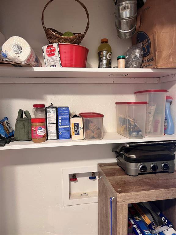 Pantry showing washer dryer connections.