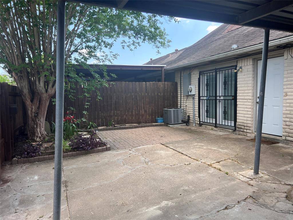 Courtyard area shaded by huge crepe myrtle. Parking for 2 cars. One covered. Double patio doors lead to family room. W/D are currently in the utility closet behind the white door. They could be moved inside the house to pantry.