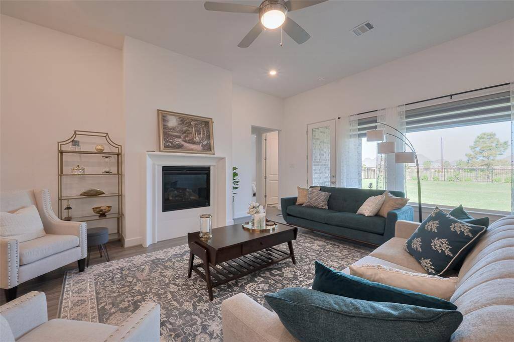 This room features large windows with views of a lush backyard, green space and water views.