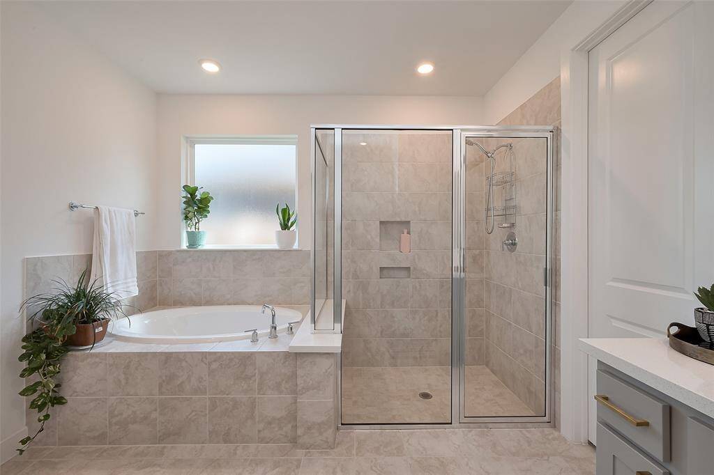 Luxurious primary bathroom featuring a separate shower and a relaxing soaker tub.