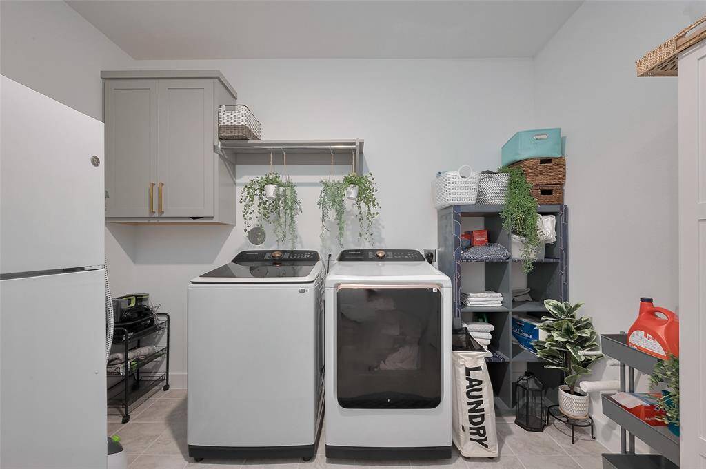 Modern, spacious laundry room equipped with sleek appliances, ample storage, and stylish shelving for an organized and efficient laundry experience.