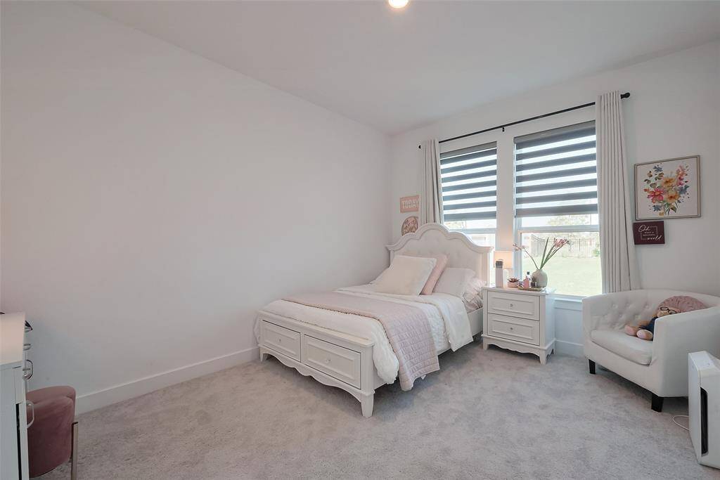 Inviting secondary bedroom with ample natural light, cozy carpeting, creating a serene retreat.