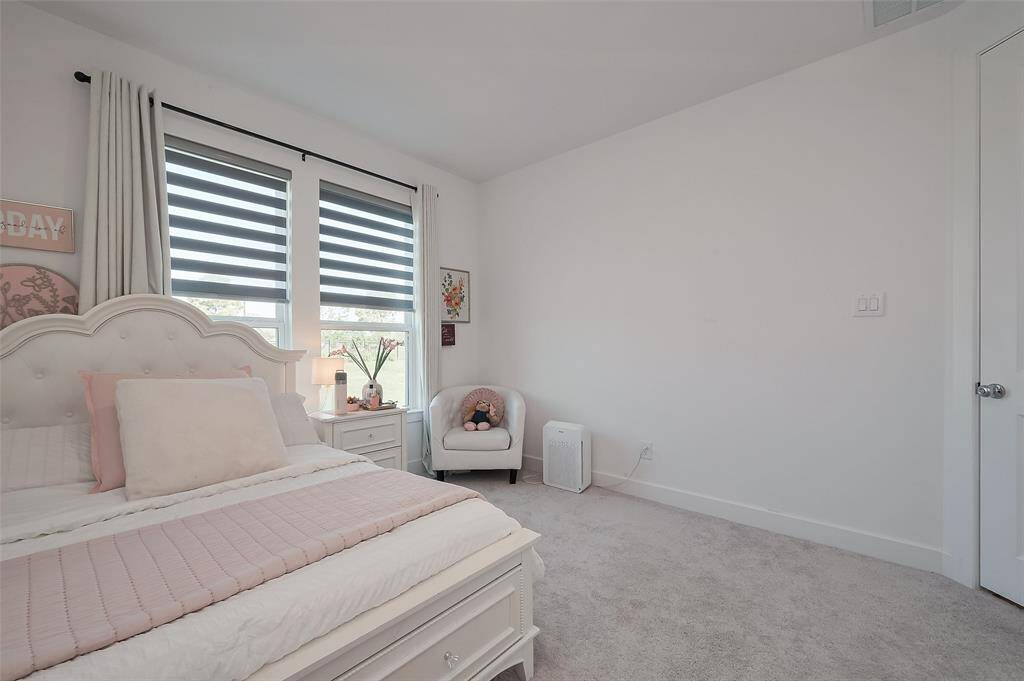 This inviting bedroom features soft, neutral tones, and ample natural light, creating a serene retreat.
