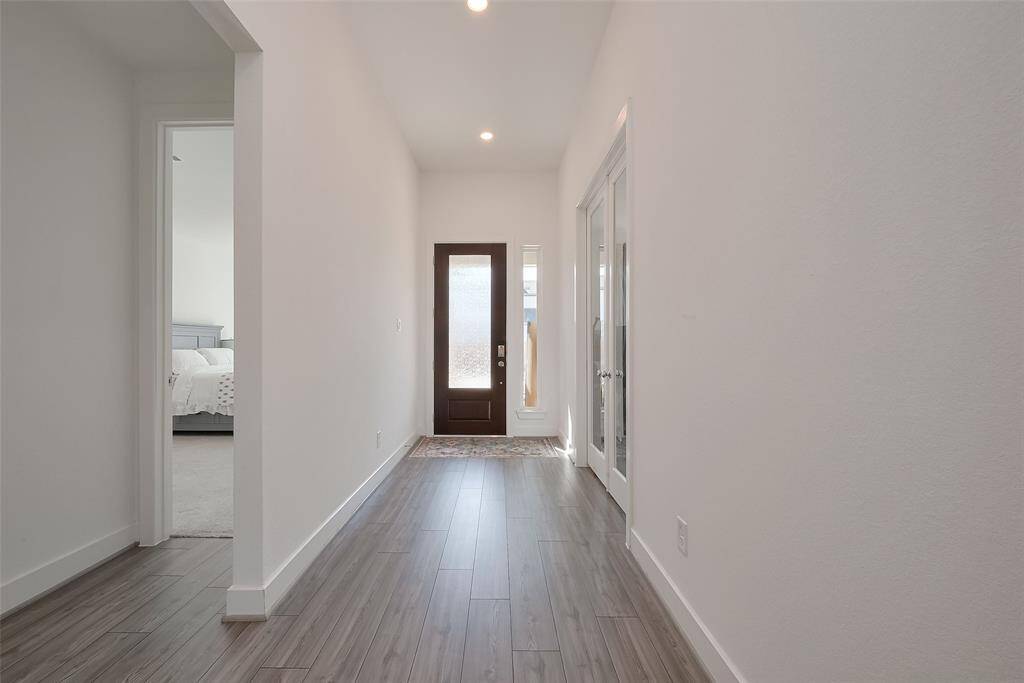Welcome to an inviting entryway featuring soaring ceilings that create a spacious and airy ambiance.
