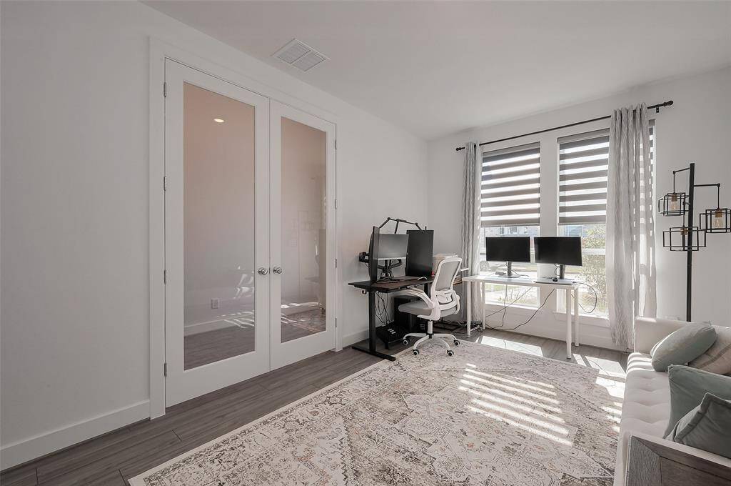 Bright and inviting home office with elegant French doors and ample natural light, perfect for productivity and comfort.