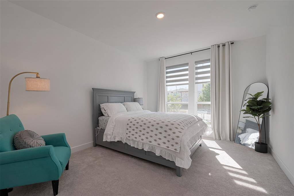 Front bedroom that is Bright and inviting featuring large windows, modern decor, and a cozy atmosphere. Ideal for relaxation.