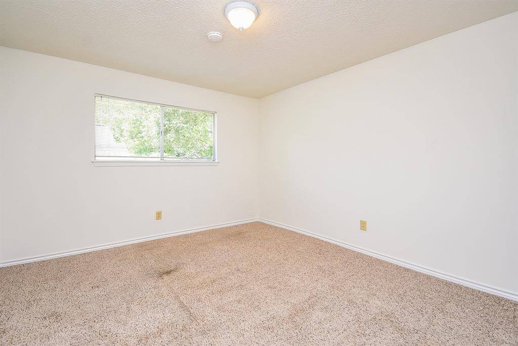Bedroom 3 features neutral walls, carpeted flooring, and a window for natural light, making it a versatile space for various uses.