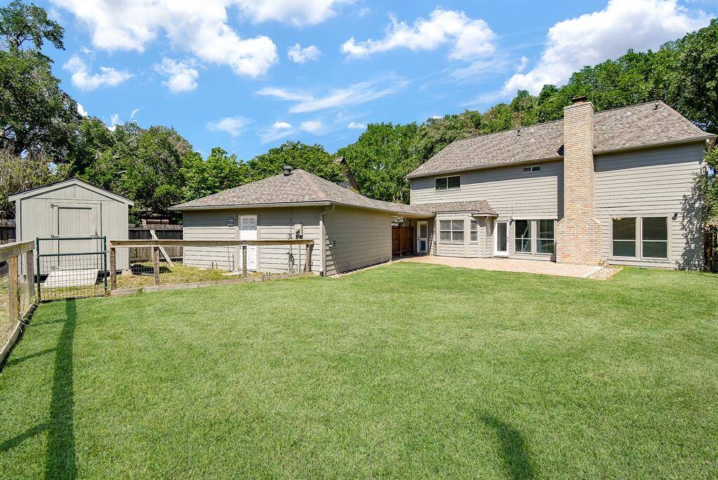Spacious backyard featuring a well-maintained lawn, a separate storage shed. Ideal for outdoor activities and gatherings.