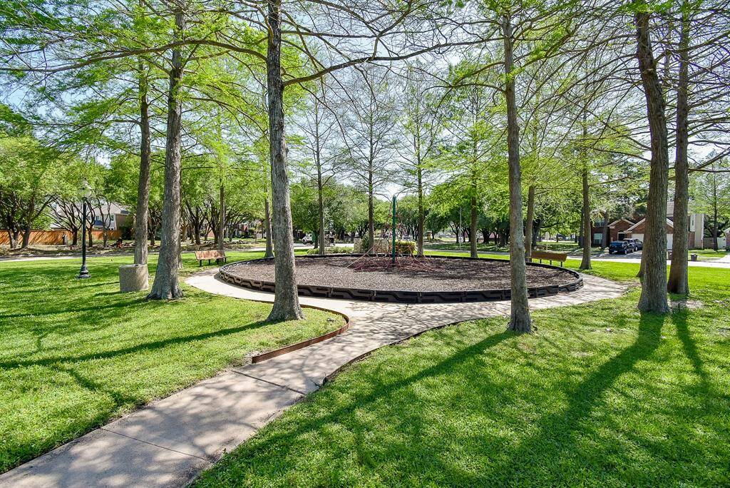 There is a serene park area with lush green grass, mature trees, and a central circular play area within a short walk. It's perfect for families and offers a peaceful environment for relaxation and outdoor activities.