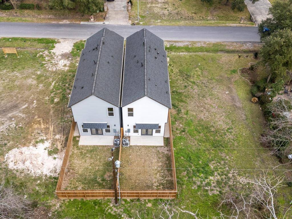 Bright, spacious room with light wood flooring, large French doors, and windows offering plenty of natural light, overlooking a fenced backyard. Ideal for a cozy living area or dining space.